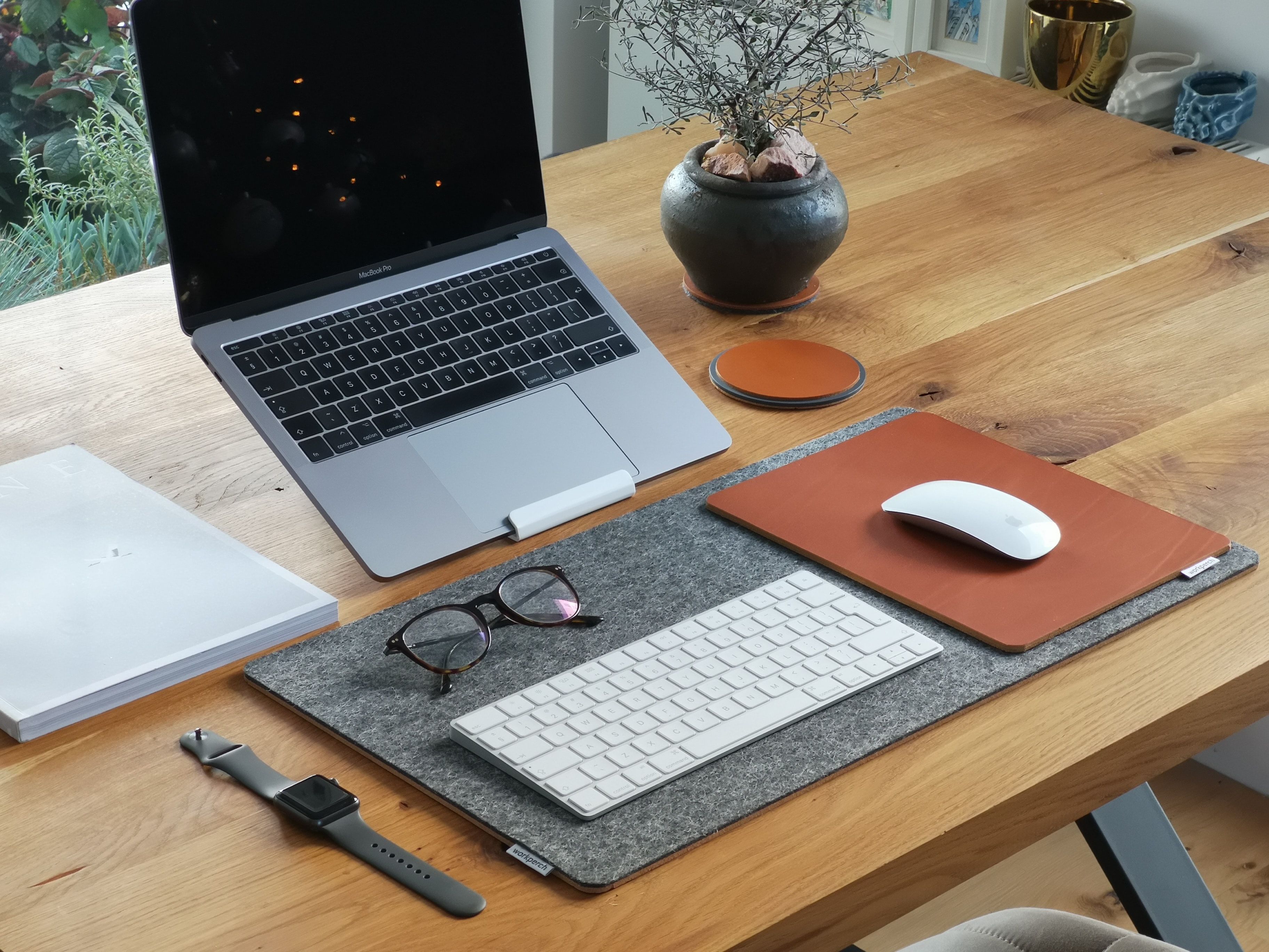 A MacBook at an upright angle on a metal stand