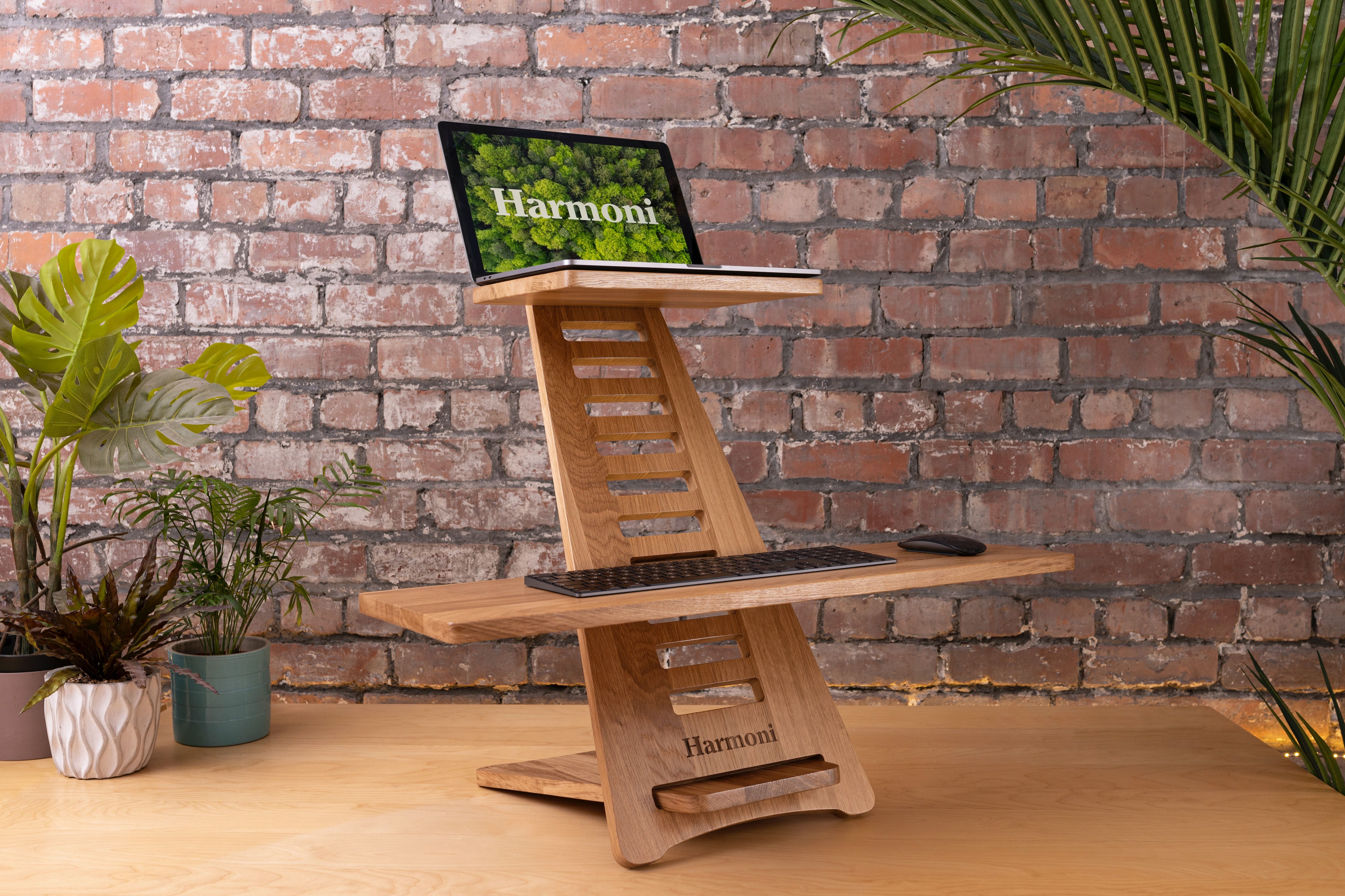 A MacBook, keyboard and mouse on a standing desk laptop stand