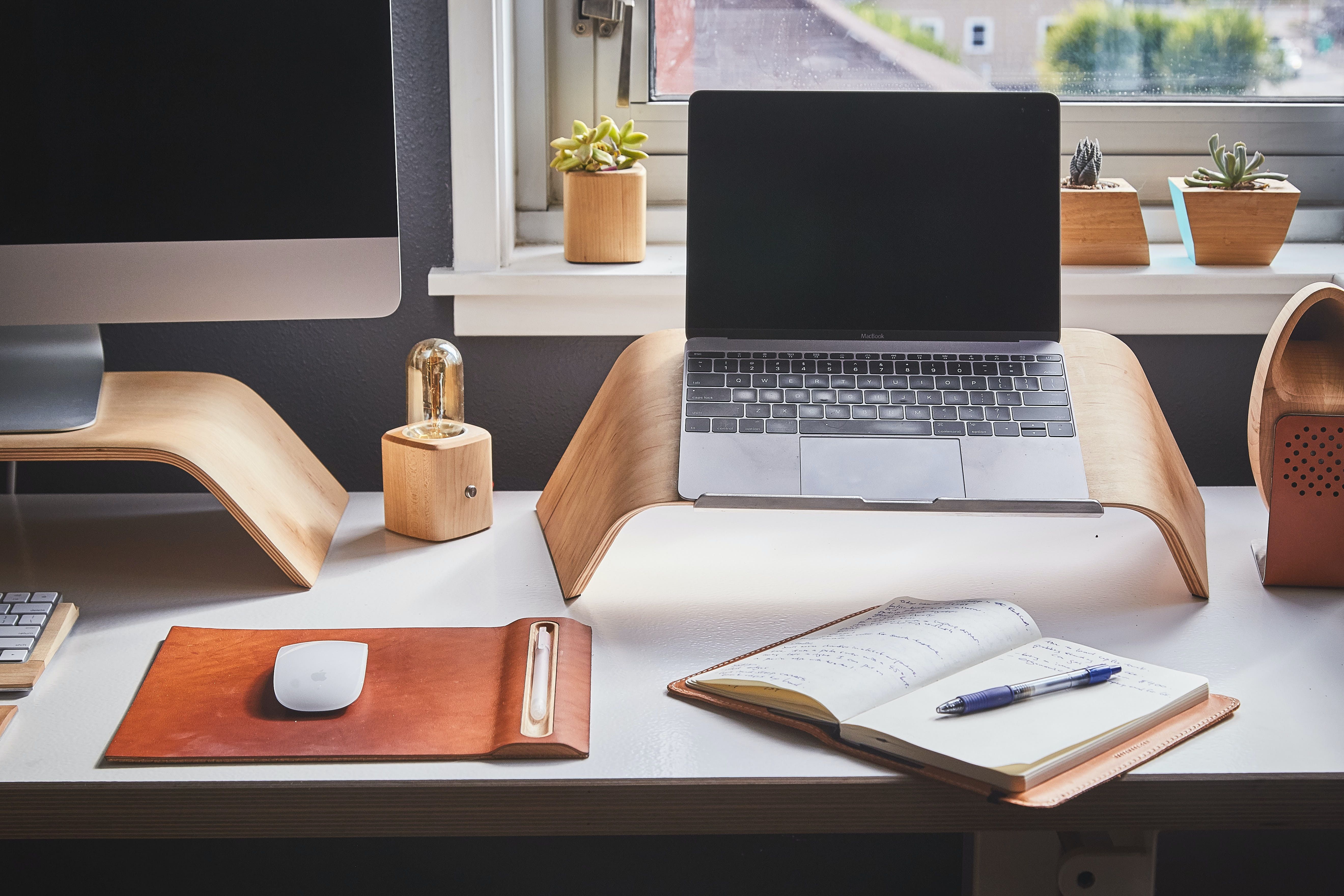 MacBook on a wooden stand on a desk